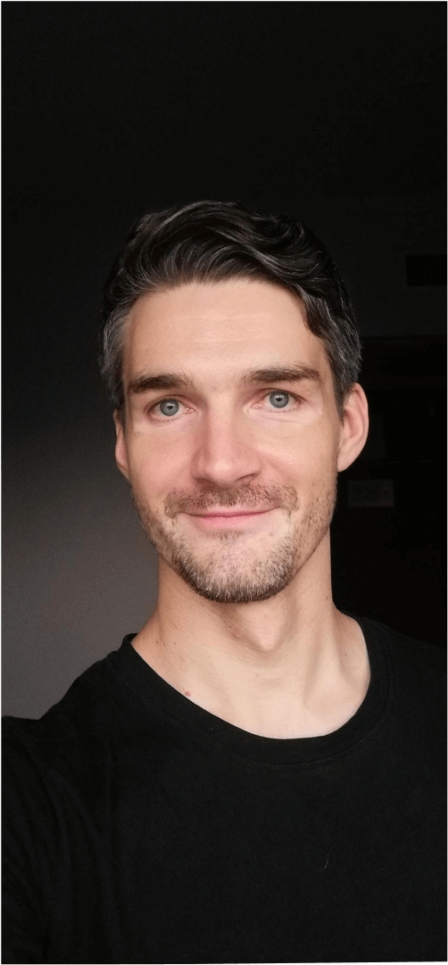 A portrait of the developer displayed on a black iPhone.